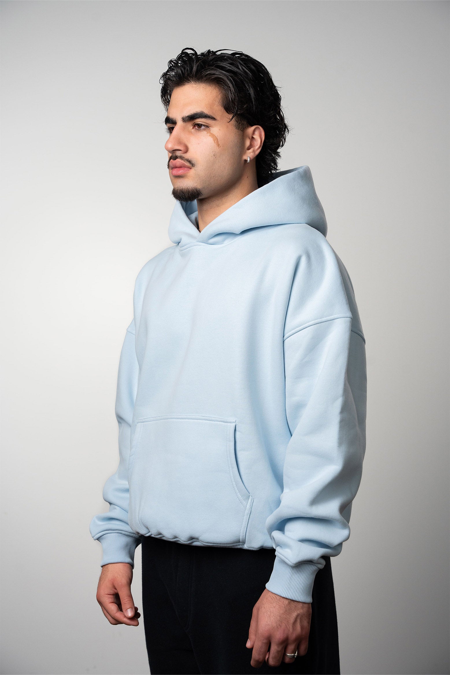 A model wearing an oversized baby blue blank hoodie