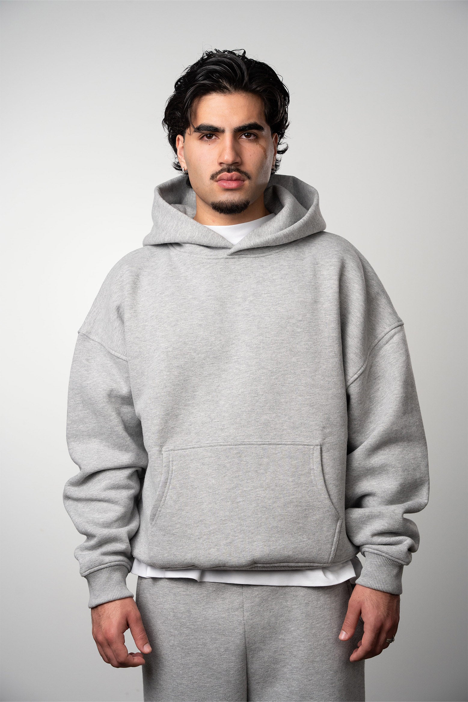 Model is wearing a grey blank hoodie with no moq