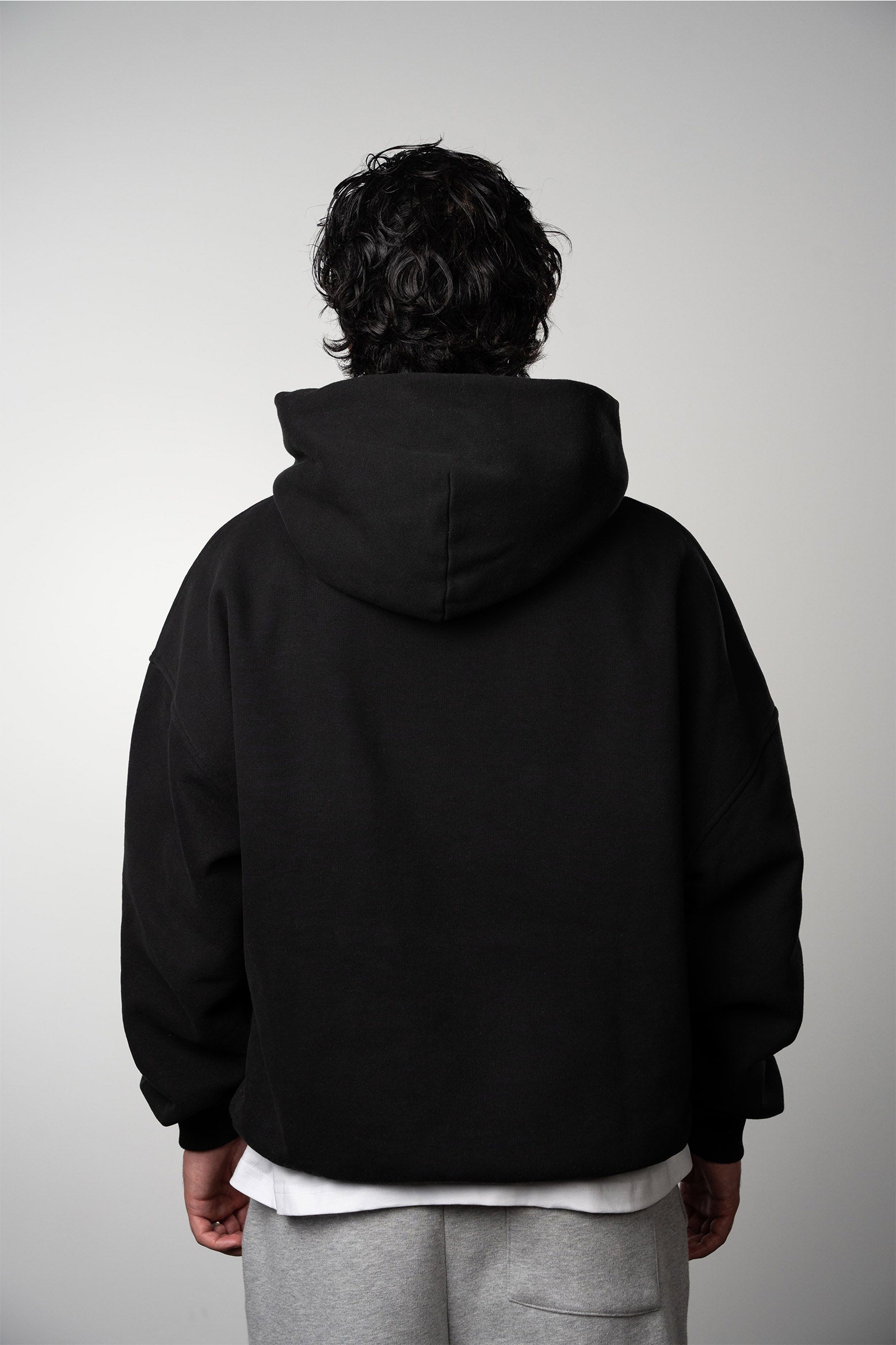 Back view of model wearing the black LEMUTA Blank hoodie