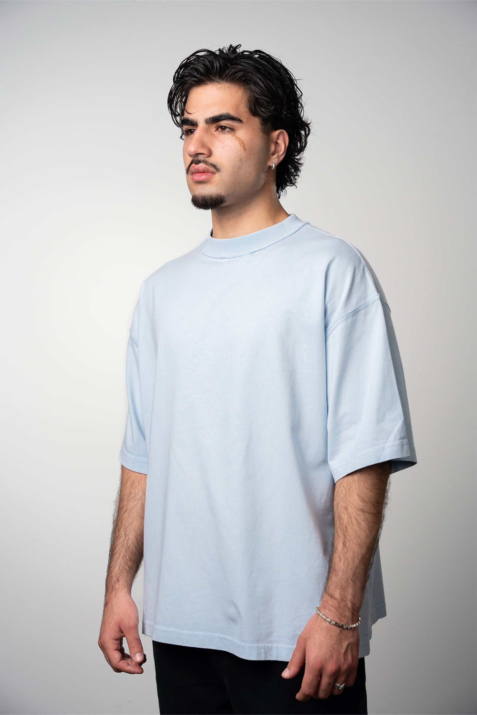 Model wearing oversized heavyweight blank tshirt in color baby blue