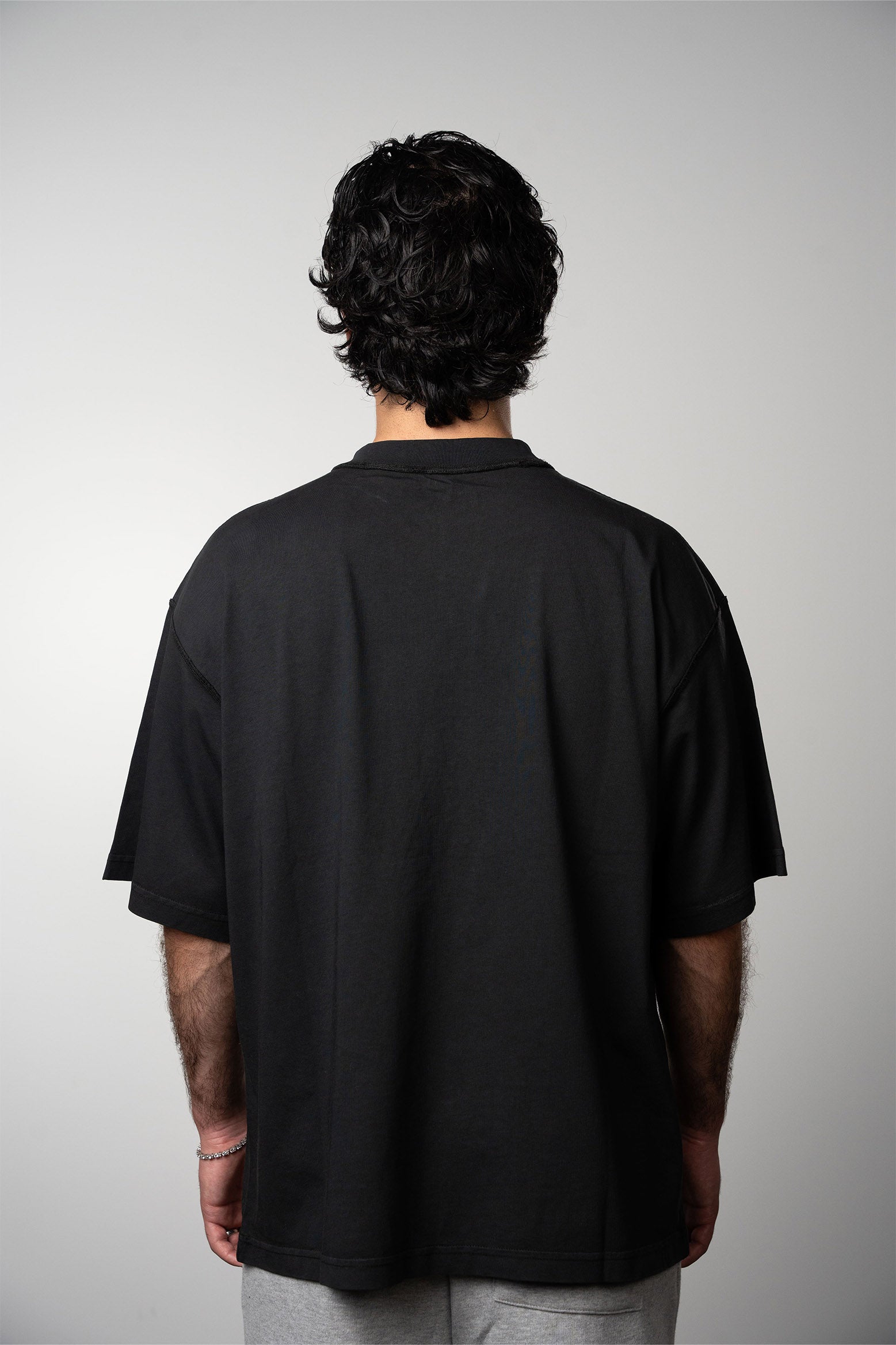 Back view of model wearing black blank tshirt