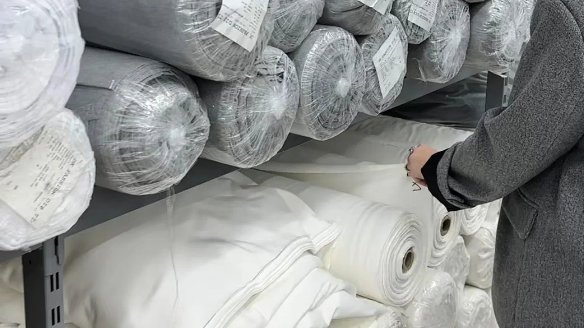 Fabric rolls in various textures and colors – highlighting material options that impact cost, feel, and quality in fashion production.